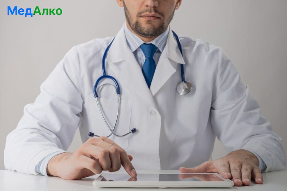 Врач нажимает на планшет Врач нажимает на планшет в клинике "МедАлко"